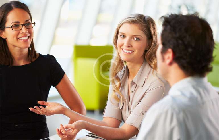 Three colleagues smiling during informal meeting